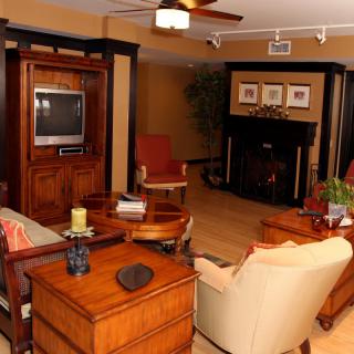 Cozy living room with wooden furniture, a television, and a fireplace.