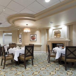 An elegant dining room with neatly arranged tables and chairs, featuring tasteful decor and soft lighting.