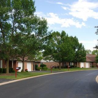 A quiet suburban street lined with houses and trees.