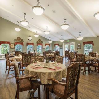 A well-lit dining area with elegantly set tables and comfortable chairs.