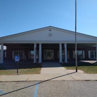 A front view of a building featuring classic architectural elements and a clear blue sky.