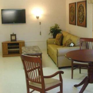 A cozy living room with a sofa, table, and a wall-mounted TV.
