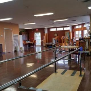 A physical therapy center equipped with parallel bars and other exercise equipment.