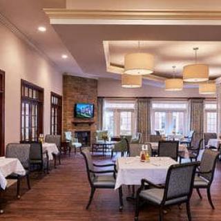 A spacious dining room with neatly arranged tables and chairs, ambient lighting, and elegant decor.