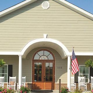 A residential building with an arched entrance and an American flag on the porch.