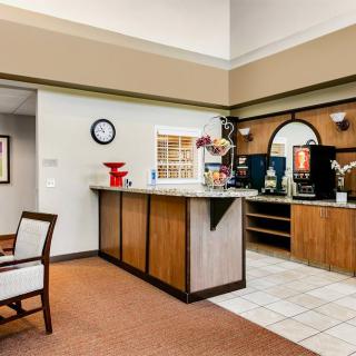 A hotel lobby with a reception desk and seating area.