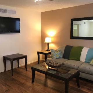 A cozy and modern living room setup featuring a comfortable sofa, a coffee table, and a television.