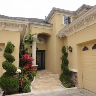 A well-maintained house entrance featuring elegant landscaping and architectural details.