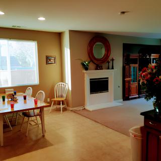 A cozy dining and living area featuring a dining table with chairs and a fireplace.