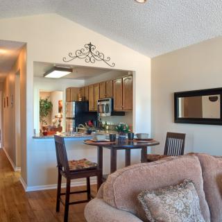 A cozy living room and kitchen area with modern furniture and decor.