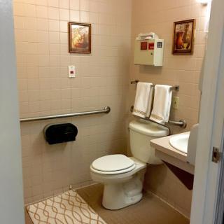 A tidy bathroom featuring essential amenities and decorative touches.