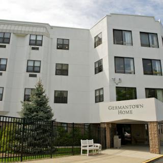 A modern residential building with a welcoming entrance and greenery.