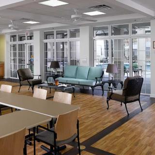 A modern lounge with comfortable seating and wooden flooring, set up as a meeting space.