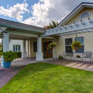 A welcoming residential house with a covered porch and well-maintained lawn.