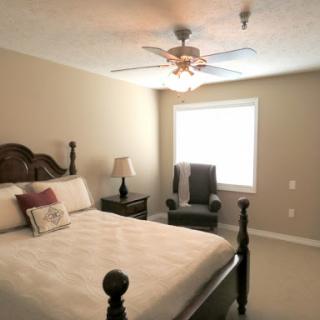 A cozy and well-lit bedroom featuring a comfortable bed and inviting seating.