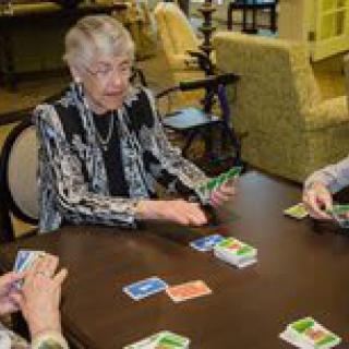 A group of elderly women enjoying a card game together indoors.