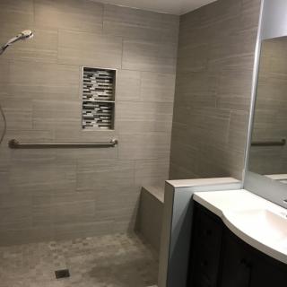 Modern bathroom with walk-in shower and gray tile design.