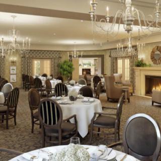 An elegant dining room with beautifully set tables and chandeliers.