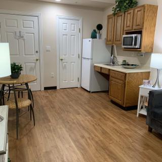 A cozy kitchen area in an apartment with wooden flooring and minimalist decor.