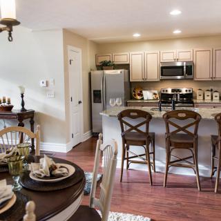 A modern kitchen with an open dining area featuring a kitchen island and elegant decor.