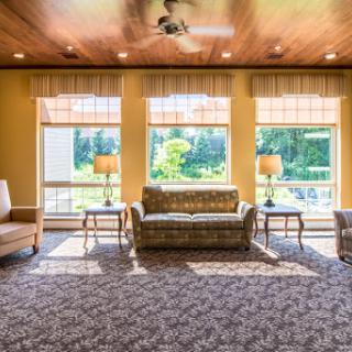 A cozy living room filled with natural light, featuring comfortable seating and a warm ambiance.