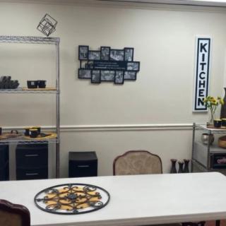 A cozy kitchen area with a table and decorative shelves.