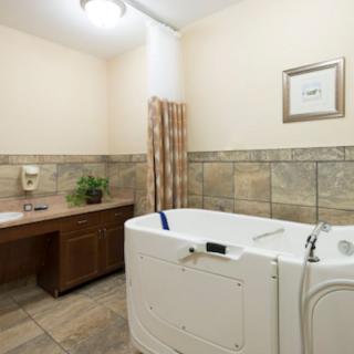 A clean and modern bathroom with a walk-in bathtub and tiled walls.