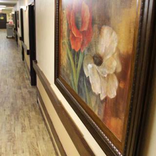 A hallway features a painting of vibrant flowers.