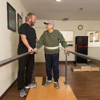 A therapist assists an elderly patient during a physical therapy session, promoting mobility and independence.