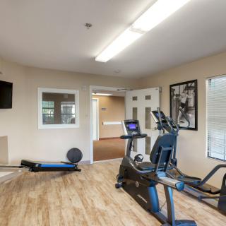 A small indoor gym with exercise equipment including a treadmill and other fitness gear.