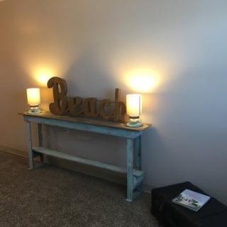 A cozy interior space featuring a table with lamps and beach-themed decor.