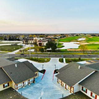 Aerial view of a suburban neighborhood with houses and a nearby golf course.