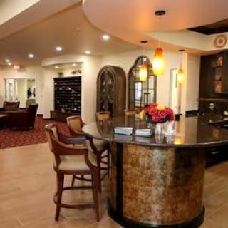 A modern bar area with seating and wine storage, featuring elegant lighting and decor.