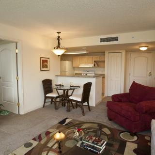 A modern living room with a small dining area and open kitchen layout.