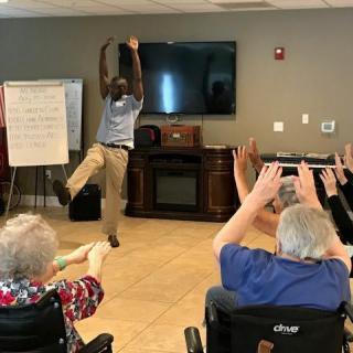 A fitness instructor leads a group of seniors in an exercise class.