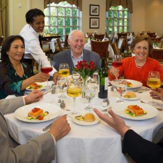 A group of people enjoying a meal together at a restaurant, with drinks and food on the table.
