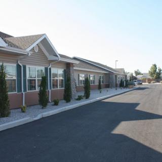 A view of a suburban residential area featuring single-story homes along a well-paved street.