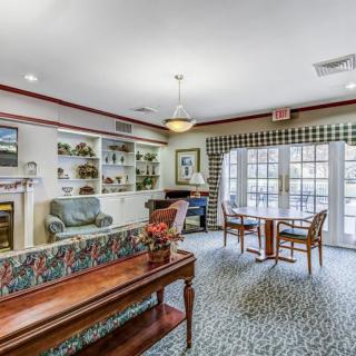 A cozy living room with comfortable seating, elegant furnishings, and ample natural light streaming through large windows.