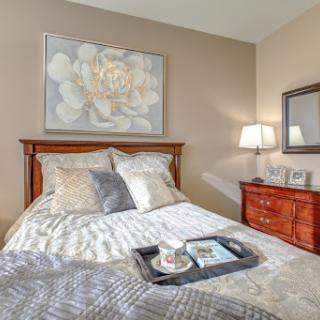 A cozy and elegantly decorated bedroom featuring a comfortable bed, stylish furniture, and tasteful artwork.