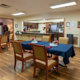 A cozy dining area with neatly set tables and a view of the kitchen.