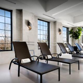 A modern relaxation area with lounge chairs and large windows.