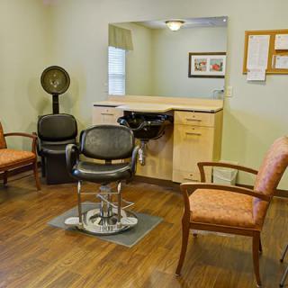A cozy hair salon with chairs, a mirror, and a hair dryer.