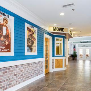 A vibrant corridor showcasing vintage movie posters against a blue wall with brick accents.