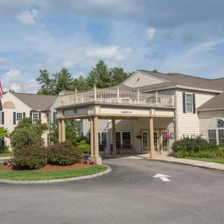 Front view of a residential building with a landscaped entrance and driveway.