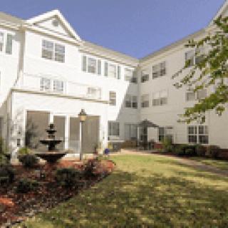 A residential building with a courtyard featuring a fountain and landscaping.
