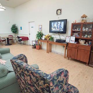 A cozy living room with a television, sofas, and wooden furniture.