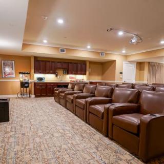 A cozy home theater with leather seating and ambient lighting.