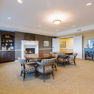 A cozy meeting room featuring elegant furniture and a warm fireplace.