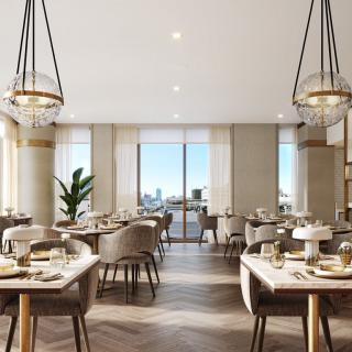 A modern dining area with elegant chandeliers and well-arranged tables, flooded with natural light from large windows.