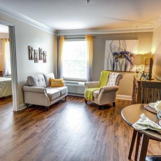 A cozy living room with modern decor, featuring comfortable seating and wood flooring.